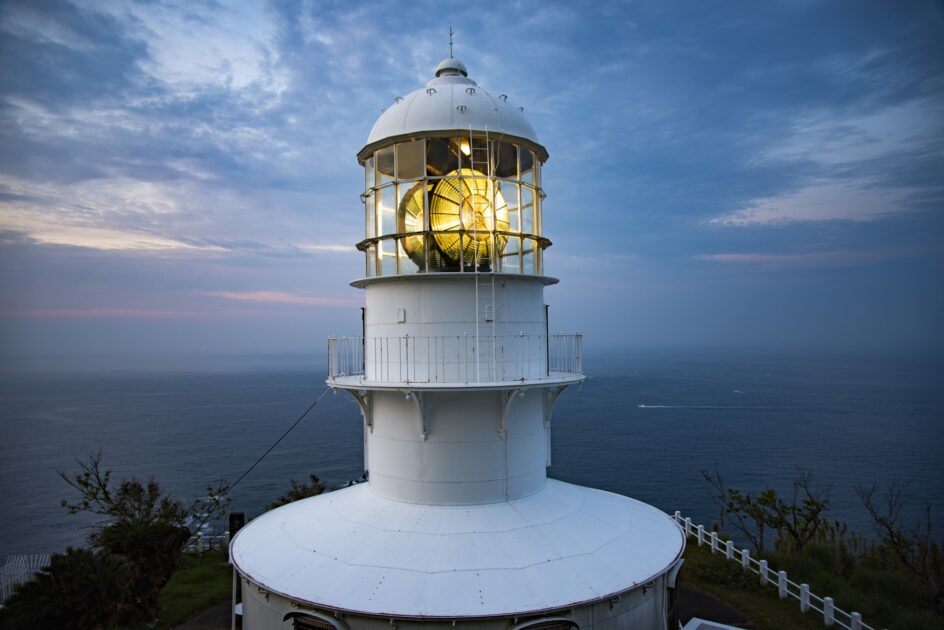 Cape Muroto Lighthouse illuminated at night above the Pacific Ocean